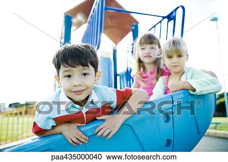 Children on playground equipment, smiling at camera View Large Photo Image Stock Image - Children on playground equipment, smiling at camera. Fotosearch