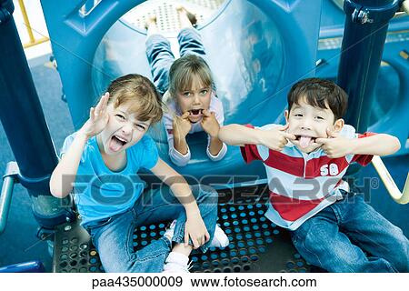 Children on playground equipment, making faces at camera View Large Photo Image Stock Photo - Children on playground equipment, making faces at camera. Fotosearch
