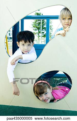 Stock Photography - Children on playground equipment, smiling at camera. Fotosearch