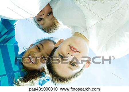 Children smiling at camera, view from directly below View Large Photo Image Stock Image - Children smiling at camera, view from directly below. Fotosearch