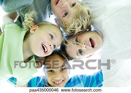 Four kids huddling, low angle view View Large Photo Image Stock Photograph - Four kids huddling, low angle view. Fotosearch