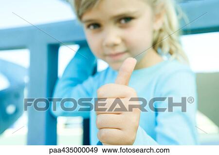 Girl giving camera thumbs up sign, focus on hand in foreground View Large Photo Image Stock Photo - Girl giving camera thumbs up sign, focus on hand in foreground. Fotosearch