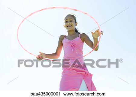 Stock Image - Girl playing with plastic hoop. Fotosearch