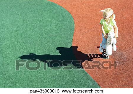 Girl sitting on playground rocking horse, high angle view View Large Photo Image Stock Image - Girl sitting on playground rocking horse, high angle view. Fotosearch