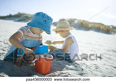 Brother and sister playing in sand at the beach View Large Photo Image Stock Image - Brother and sister playing in sand at the beach. Fotosearch