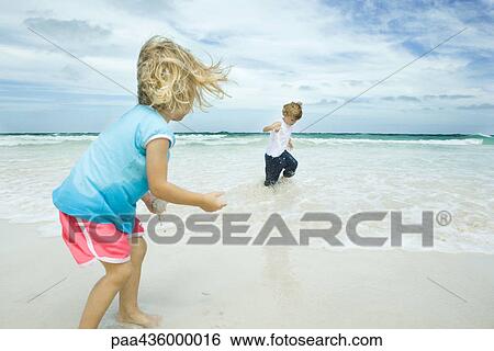 Brother and sister standing in surf View Large Photo Image Stock Photograph - Brother and sister standing in surf. Fotosearch