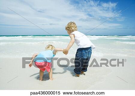 Brother and sister standing in surf View Large Photo Image Stock Photography - Brother and sister standing in surf. Fotosearch