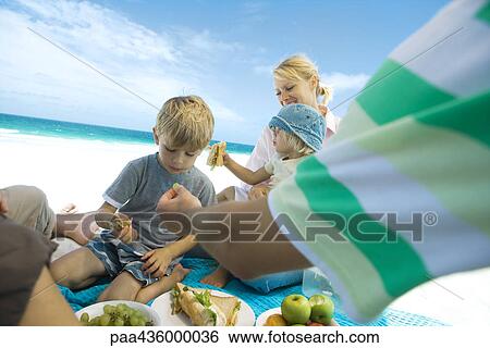 Stock Photograph - Family having picnic on beach. Fotosearch