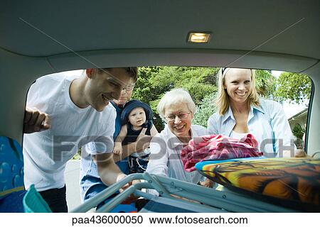 Family unloading beach material out of trunk of car View Large Photo Image Stock Image - Family unloading beach material out of trunk of car. Fotosearch