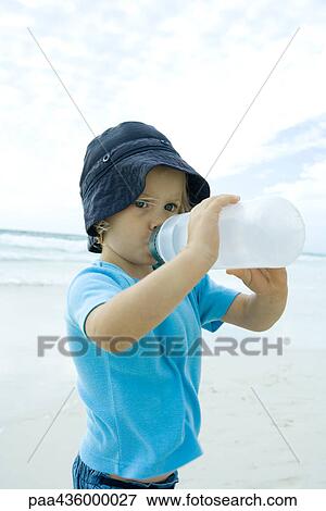 Girl drinking from water bottle on beach View Large Photo Image Stock Photo - Girl drinking from water bottle on beach. Fotosearch