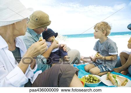 Grandparents and grandchildren having picnic on beach View Large Photo Image Stock Photo - Grandparents and grandchildren having picnic on beach. Fotosearch