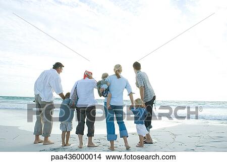 Picture - Three generation family standing on beach. Fotosearch