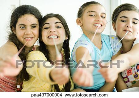 Four young female friends pulling chewing gum out of mouths View Large Photo Image Picture - Four young female friends pulling chewing gum out of mouths. Fotosearch
