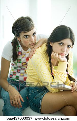 Stock Photo - Two young female friends slouching and looking bored, looking at camera, portrait. Fotosearch