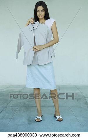 Woman holding up shirt, full length View Large Photo Image Stock Image - Woman holding up shirt, full length. Fotosearch