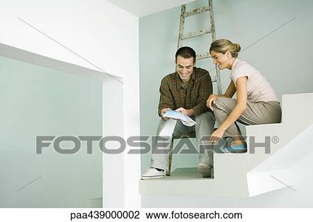 Stock Image - Couple looking at paint swatches. Fotosearch