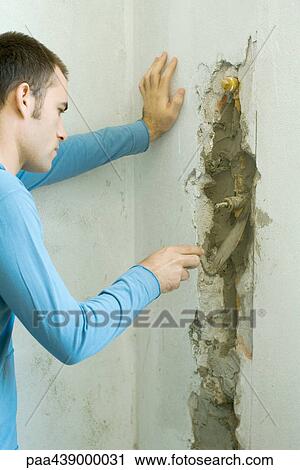 Man filling in hole in wall with grout View Large Photo Image Stock Image - Man filling in hole in wall with grout. Fotosearch
