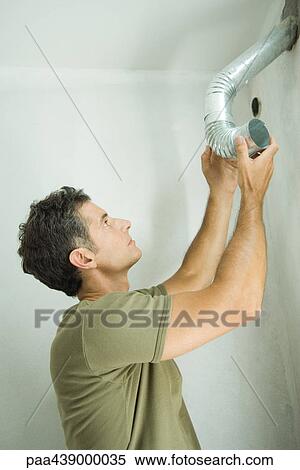 Stock Photography - Man holding up pipe. Fotosearch