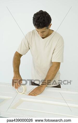 Man putting masking tape on door View Large Photo Image Stock Photograph - Man putting masking tape on door. Fotosearch