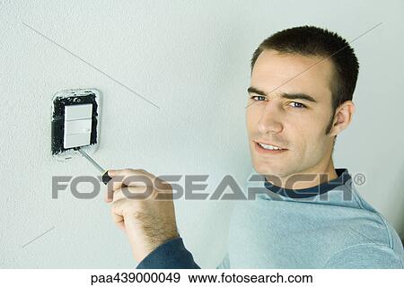 Man removing light switch cover from wall View Large Photo Image Stock Photo - Man removing light switch cover from wall. Fotosearch