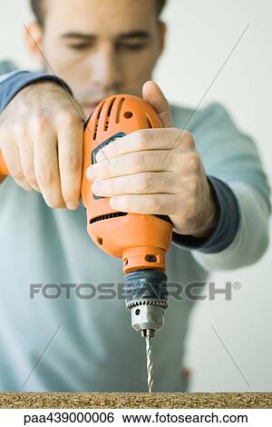 Man using drill View Large Photo Image Stock Photograph - Man using drill. Fotosearch