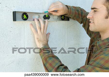 Man using level to draw line on wall View Large Photo Image Stock Photo - Man using level to draw line on wall. Fotosearch
