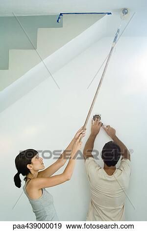 Woman painting ceiling with paint roller while man changes lightbulb View Large Photo Image Stock Photo - Woman painting ceiling with paint roller while man changes lightbulb. Fotosearch