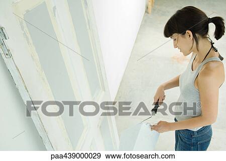 Stock Photo - Woman painting door. Fotosearch