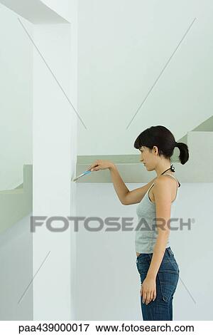 Woman painting wall with paint brush View Large Photo Image Stock Photo - Woman painting wall with paint brush. Fotosearch