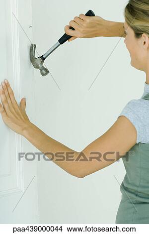 Woman removing nail from wall View Large Photo Image Picture - Woman removing nail from wall. Fotosearch