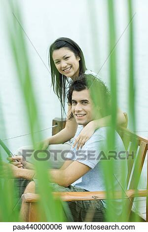 Stock Photograph - Couple fishing on dock together, smiling at camera. Fotosearch
