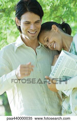 Couple, woman resting head on man's shoulder and holding newspaper View Large Photo Image Stock Photography - Couple, woman resting head on man's shoulder and holding newspaper. Fotosearch