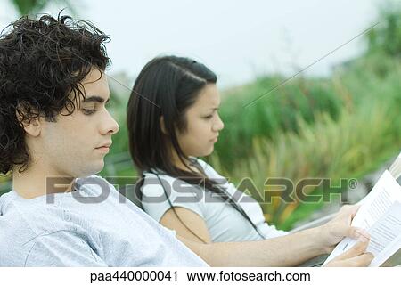 Young couple reading outdoors View Large Photo Image Stock Image - Young couple reading outdoors. Fotosearch