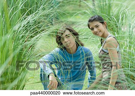Young couple sitting in grass View Large Photo Image Stock Image - Young couple sitting in grass. Fotosearch
