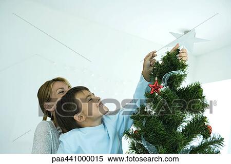 Boy and mother decorating Christmas tree View Large Photo Image Stock Photography - Boy and mother decorating Christmas tree. Fotosearch