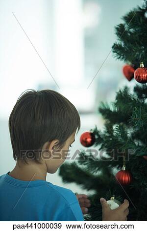Boy decorating Christmas tree View Large Photo Image Stock Photo - Boy decorating Christmas tree. Fotosearch