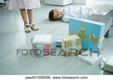 Boy lying on floor next to presents View Large Photo Image Stock Image - Boy lying on floor next to presents. Fotosearch