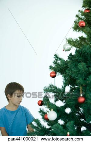 Boy standing near Christmas tree View Large Photo Image Stock Image - Boy standing near Christmas tree. Fotosearch