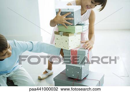 Brother and sister taking presents from stack View Large Photo Image Stock Image - Brother and sister taking presents from stack. Fotosearch