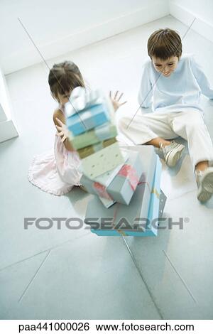 Children sitting next to stack of presents View Large Photo Image Stock Photograph - Children sitting next to stack of presents. Fotosearch