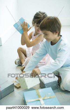 Children sitting on floor picking up presents View Large Photo Image Stock Photo - Children sitting on floor picking up presents. Fotosearch