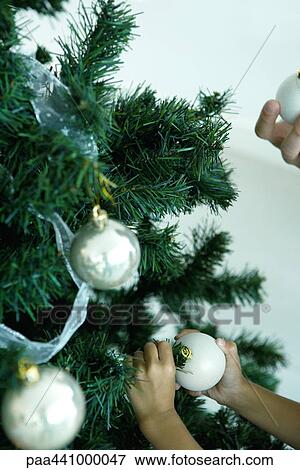 Stock Photo - Decorating Christmas tree. Fotosearch