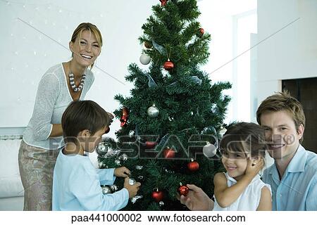 Family decorating Christmas tree View Large Photo Image Stock Image - Family decorating Christmas tree. Fotosearch