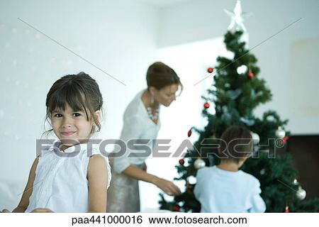 Family decorating Christmas tree View Large Photo Image Stock Photograph - Family decorating Christmas tree. Fotosearch