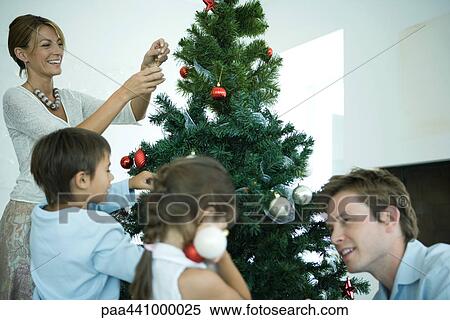 Family decorating Christmas tree View Large Photo Image Stock Photography - Family decorating Christmas tree. Fotosearch