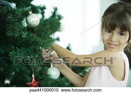Girl decorating Christmas tree View Large Photo Image Stock Image - Girl decorating Christmas tree. Fotosearch