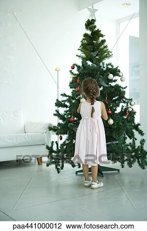 Girl decorating Christmas tree View Large Photo Image Stock Image - Girl decorating Christmas tree. Fotosearch