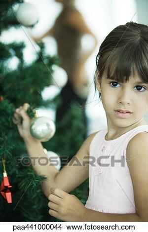 Girl holding branch of Christmas tree View Large Photo Image Picture - Girl holding branch of Christmas tree. Fotosearch
