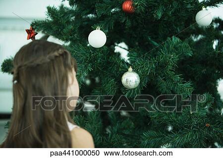 Girl looking at Christmas tree View Large Photo Image Stock Image - Girl looking at Christmas tree. Fotosearch