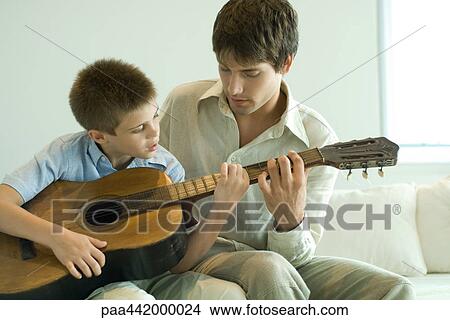 Father and son playing guitar together View Large Photo Image Picture - Father and son playing guitar together. Fotosearch